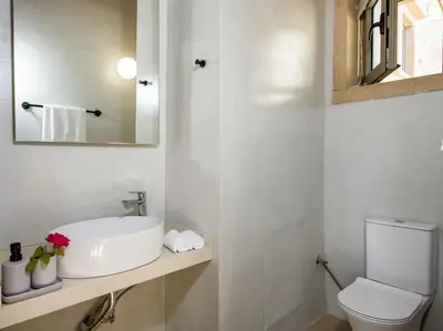 a white bathroom with a sink and a toilet at Casa di Grimpili in Kolymvari