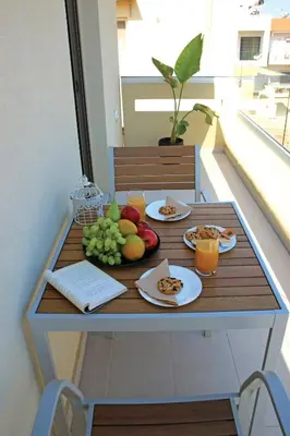 a table with food and fruit on a balcony at New Cozy Chic Apt-Ryfete Luxury Living in Kalathas