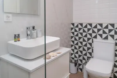 a white bathroom with a sink and a toilet at Fragios Beach House in Chania Town