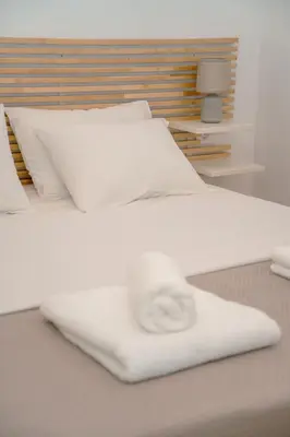 a white bed with white pillows at Fragios Beach House in Chania Town