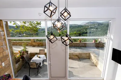 a room with a door and a view of a patio at Rikanthos Stone Sea View Apartment Ι in Falelianá