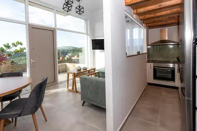 a kitchen with a table and a dining room with a view at Rikanthos Stone Sea View Apartment Ι in Falelianá