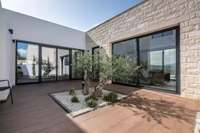 a house with a tree in the middle of a courtyard at Villas Phos and Kallos in Kissamos