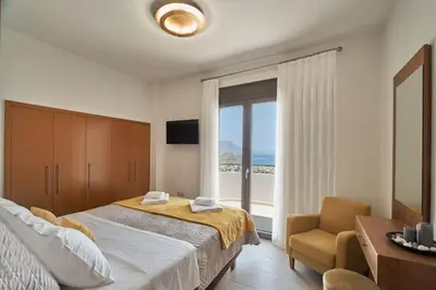 a bedroom with a bed and a chair and a window at Luxury Villa Argi infinity private pool in Kissamos