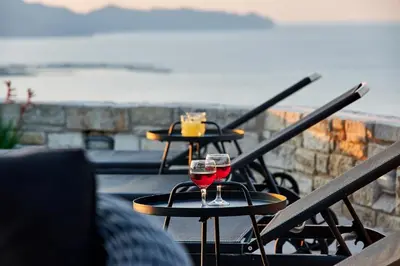 two glasses of red wine sitting on tables on a balcony at Luxury Villa Argi infinity private pool in Kissamos