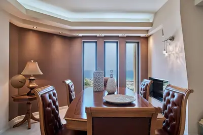 a dining room with a table and chairs and a television at Luxury Villa Argi infinity private pool in Kissamos