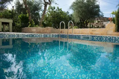 a large swimming pool with blue tiles on it at Villa Eleonas in Vamos