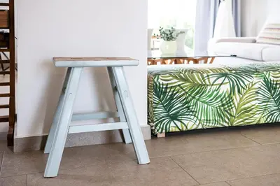 a stool in a living room next to a couch at VILLA AMANTELLA in Stavros