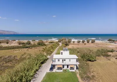 an aerial view of a white house on the beach at SEA BREEZE APARTMENTS in Kolymvari