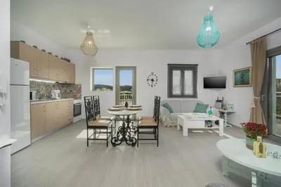 a kitchen and living room with a table and chairs at SEA BREEZE APARTMENTS in Kolymvari