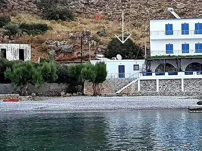 a white building next to a body of water at EDEM HOUSE FINIKAS in Loutro