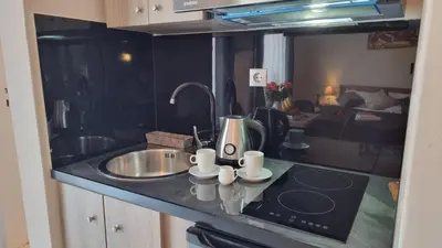a kitchen with a sink and a counter top with cups at Secret Garden Hotel in Maleme
