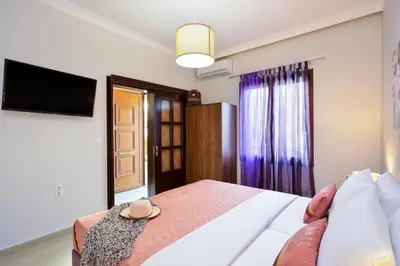 a bedroom with a bed and a flat screen tv at CASA MARIGO (OLD HARBOUR) in Chania Town