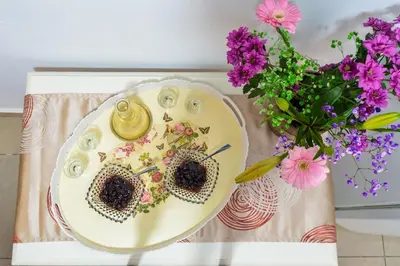 a plate with two hearts on it next to a vase of flowers at CASA MARIGO (OLD HARBOUR) in Chania Town