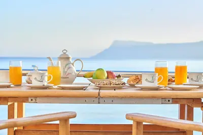 a table with food and glasses of orange juice at Sea View House in Kissamos
