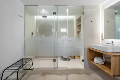 a bathroom with a glass shower and a sink at Monk Rooms in Chania Town