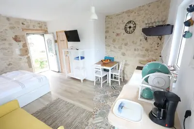a room with a bed and a table with a sink at Ravi Boutique Home - 1 minute walk from beach in Kalyves