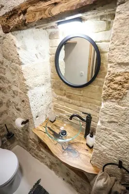 a bathroom sink with a mirror on a stone wall at Ravi Boutique Home - 1 minute walk from beach in Kalyves
