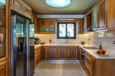 a kitchen with wooden cabinets and a refrigerator at Villa Alexandra in Kolymvari