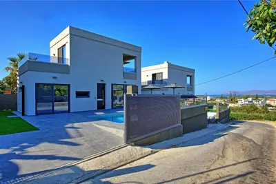 a large white house with a swimming pool at Villa Maripol by PosarelliVillas in Galatás