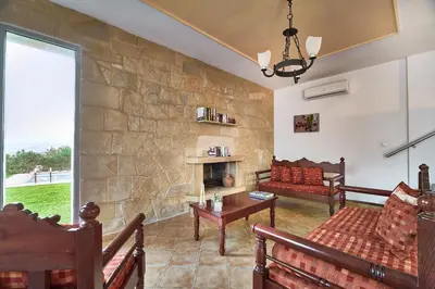 a living room with a stone wall at Villa Politini by PosarelliVillas in Vryses