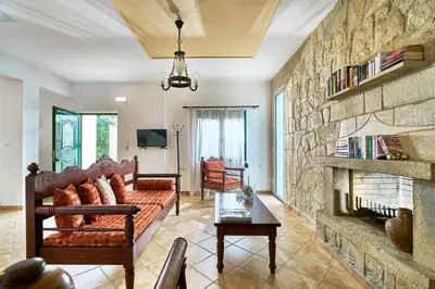 a living room with a couch and a stone wall at Villa Politini by PosarelliVillas in Vryses