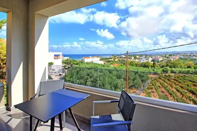 a balcony with a table and chairs and a view of the ocean at Villa Popi - modern villa with private pool by PosarelliVillas in Galatás