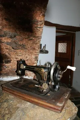 an old sewing machine sitting on top of a table at Afrodite's House-Restaurated Oil Factory in Ayiá
