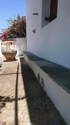 a building with a vase sitting next to a wall at Afrodite's House-Restaurated Oil Factory in Ayiá