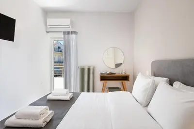 a bedroom with a large white bed with towels on it at West City Apartment in Chania Town