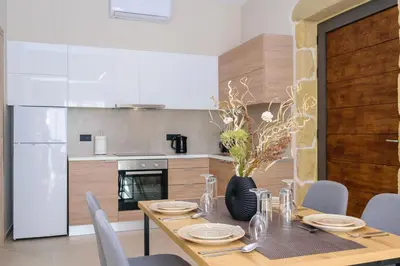 a kitchen with a wooden table and a dining room at Effrosini Panorama View in Nopíyia