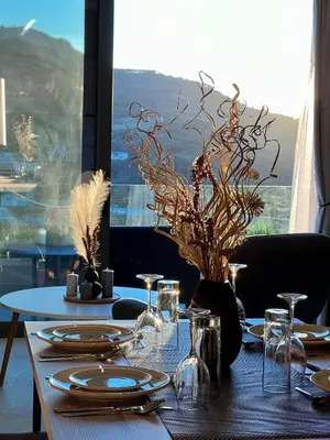 a table with plates and glasses on a table with a window at Effrosini Panorama View in Nopíyia
