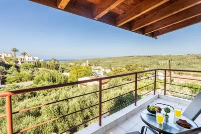 a balcony with a table and chairs and a view at SpiliaInn in Spiliá