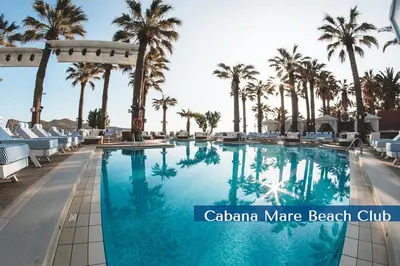 a swimming pool at a resort with palm trees at Cabanavillas Rio by PosarelliVillas in Agia Marina Nea Kydonias