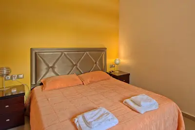 a bedroom with a large bed with two towels on it at Cabanavillas Rio by PosarelliVillas in Agia Marina Nea Kydonias