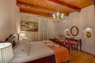 a bedroom with a bed and a table and a chair at Villa Despanto by PosarelliVillas in Litsárdha