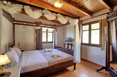 a bedroom with a canopy bed with towels on it at Villa Sevi Grande by PosarelliVillas in Káto Vení