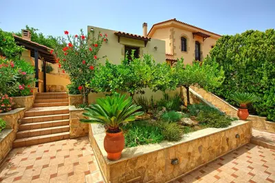 a house with a garden with potted plants and stairs at Villa Sevi Grande by PosarelliVillas in Káto Vení