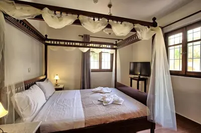 a bedroom with a canopy bed with towels on it at Villa Sevi Grande by PosarelliVillas in Káto Vení