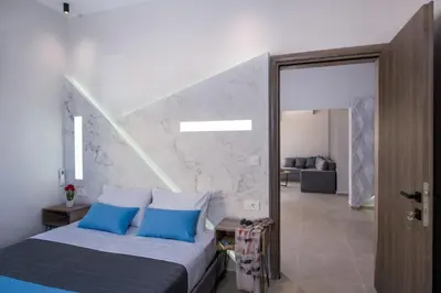 a bedroom with a bed with blue pillows at Luxury Villa Eva-Mari with jacuzzi, 50m from the beach in Stalos