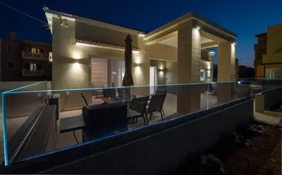 a villa with a swimming pool at night at Luxury Villa Eva-Mari with jacuzzi, 50m from the beach in Stalos