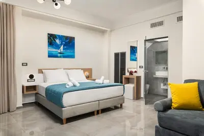 a bedroom with a bed and a couch at Archin Boutique suites in Chania Town