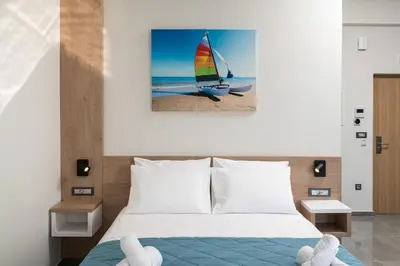 a bedroom with a bed with a sailboat on the beach at Archin Boutique suites in Chania Town