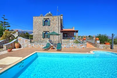 a villa with a swimming pool in front of a house at Villa Antina by PosarelliVillas in Litsárdha