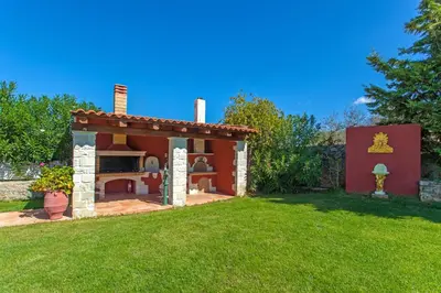 a small house with a fireplace in a yard at Villa Antina by PosarelliVillas in Litsárdha