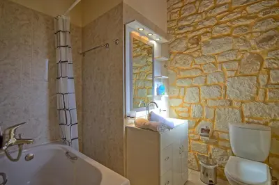 a bathroom with a tub and a toilet and a sink at Villa Vrisses by PosarelliVillas in Vryses