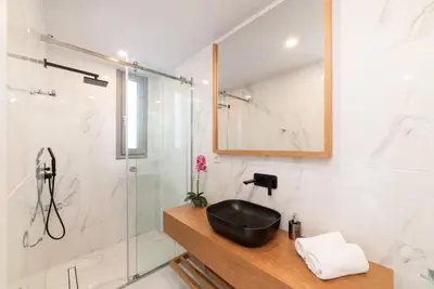 a bathroom with a sink and a shower at Villa Ampela by PosarelliVillas in Agia Marina Nea Kydonias
