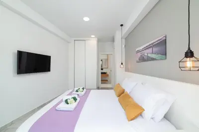 a white room with a bed and a tv at Villa Zaneti by PosarelliVillas in Agia Marina Nea Kydonias