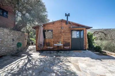 a small wooden cabin with a table and chairs at Wooden House Apts - Between Balos & Elafonissi in Kaláthenai