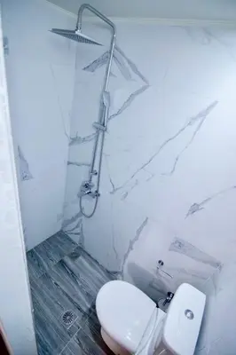 a white bathroom with a toilet and a shower at Ampelos Cretan Villa - Private Pool & Heated Ozone Jacuzzi in Gerolakkos
